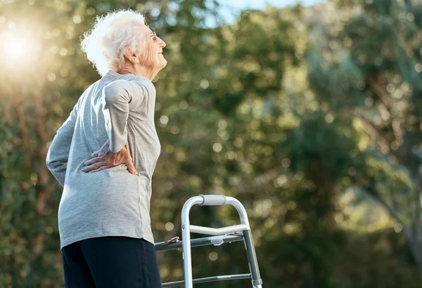 高齢女性 腰痛や関節炎のための運動公園でのリハビリテーションのための歩行フレーム 線維筋痛や骨粗しょう症の問題 引退後の空気 希望と自由のための自然の中で老婦人 — ストック写真