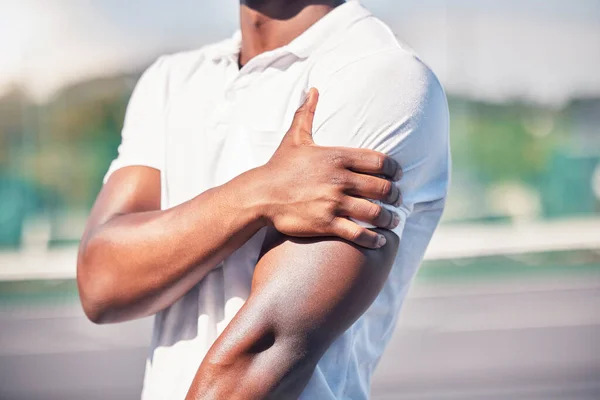 Black man, hand and arm pain from healthcare accident or medical wellness emergency outdoor. African person, shoulder injury and broken bone, hurt muscle or arthritis during fitness workout on court.