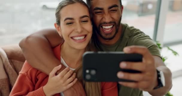 ソーシャルメディア リラックスやインターネットのための電話でソファの上のカップルと愛 自撮りや笑顔を一緒に 絆と幸せのために自宅でリビングルームで男と女とのアプリ Wifiと技術 — ストック動画