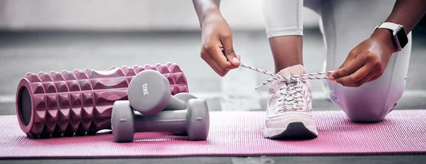 Fitness, weights and woman tying shoes before workout in gym for health, wellness and strength. Sports, training and closeup of athlete with laces to tie while preparing to exercise in a sport center.