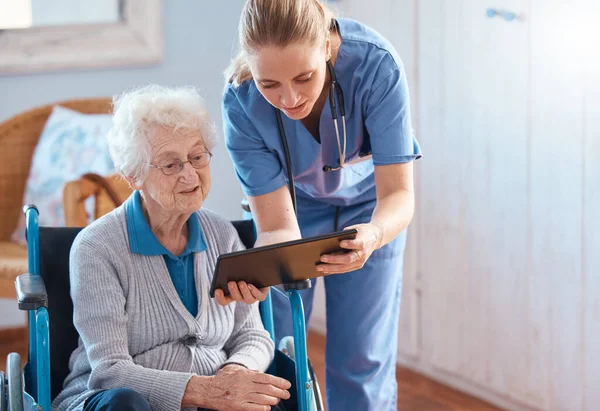 医療結果 オンラインまたはソーシャルメディアのチャートをチェックするタブレット付きの介護ホーム 女性または医師 ヘルスケア テクノロジー 看護師は リビングやベッドルームで高齢者と相談するのに役立ちます — ストック写真