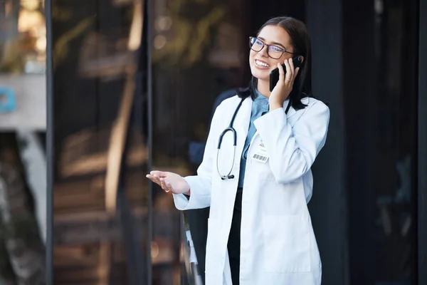 Doctor, phone call and talking for communication, funny conversation and telehealth with contact outdoor in the city. Medical worker, healthcare expert or woman speaking on mobile smartphone on break.