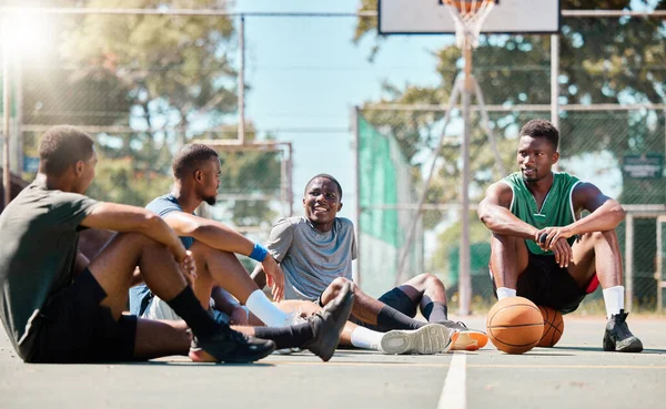 Basketball court, men and friends talking about game, sports and training motivation after exercise, workout or competition. Black man with street ball team at community playground planning strategy.