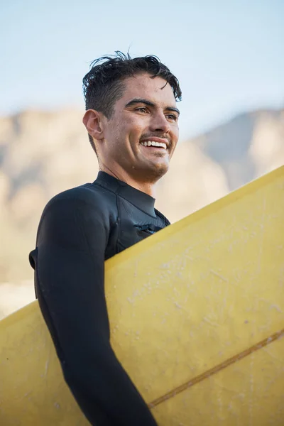 Happy surfer, man carrying surfboard and board for surfing sport on ocean waves for fitness workout, summer wellness surf and water training exercise. Beach freedom, sea wetsuit and surf in Australia.