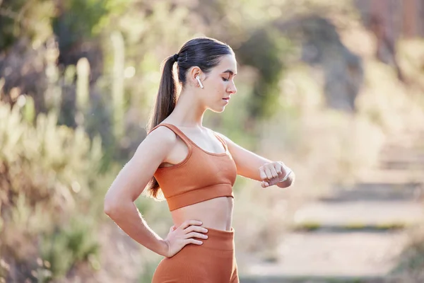 Fitness, woman and smart watch time for running, park exercise workout and outdoor training. Stopwatch, digital clock and athlete technology, check cardio progress and monitor healthy body wellness.