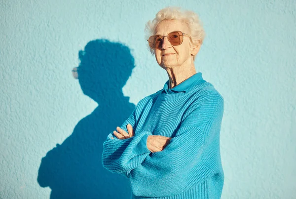 ファッション サングラス 腕を持つ老婦人の肖像画は スタイリッシュな クールでユニークな審美的なために壁の背景に交差しました 美しさとデザイナーブランドのメガネと高齢者の女性モデル — ストック写真