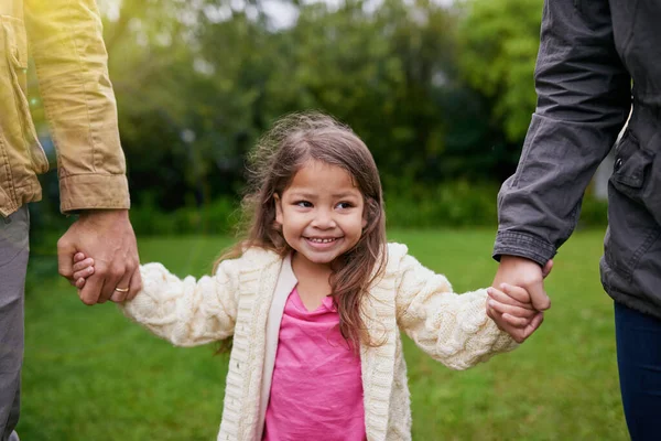 彼女の両親の手の中に安全な 公園で一日を楽しむ3人の若い家族が — ストック写真