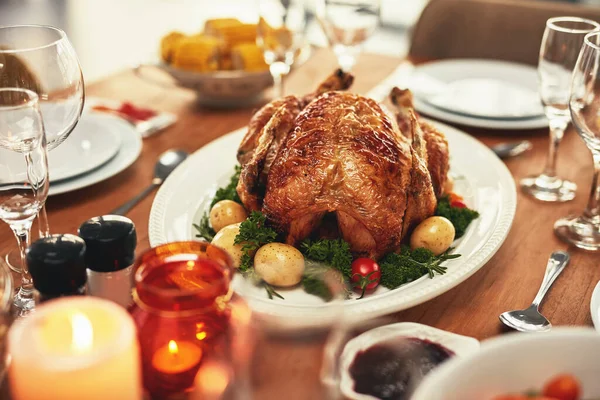 Thanksgiving, turkey and food on a dinner table for a celebration event, feast or holiday season. Christmas, chicken and meal with a roast dish on a wooden surface for hunger or a special occasion.