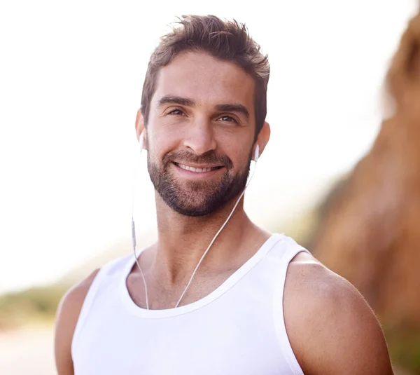 stock image Time for a relaxing run. a handsome young man standing outdoors with earphones