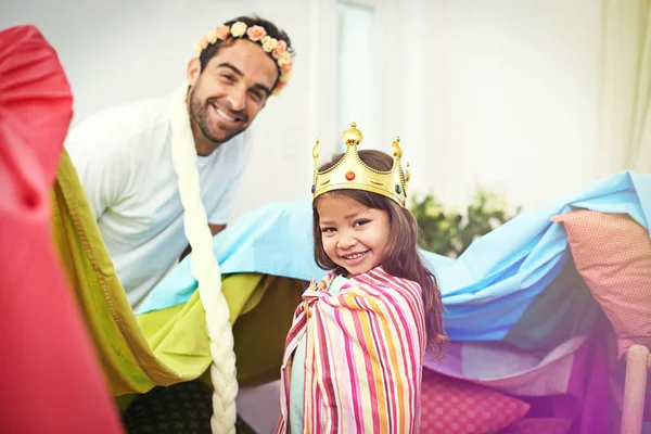 Shes daddys little princess. A cute little girl dressed up as a princess while playing at home with her dad