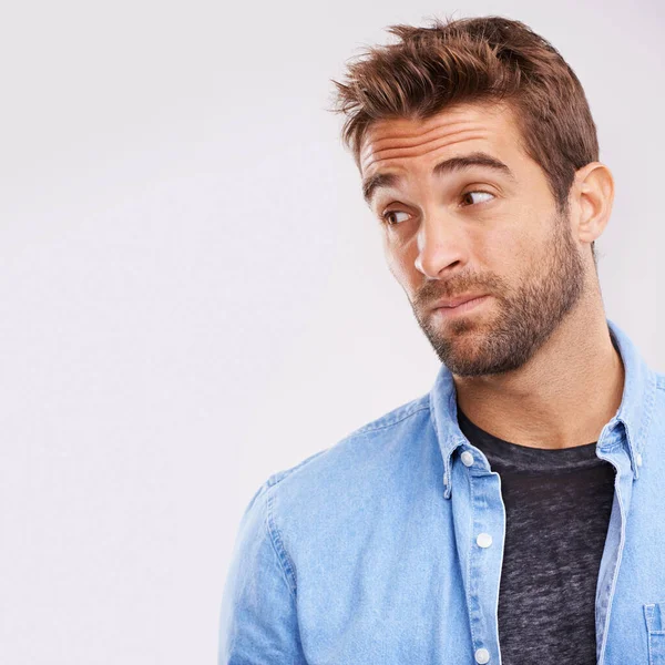 stock image Feeling unsure. Studio shot of a handsome young man looking uncertain against a gray background