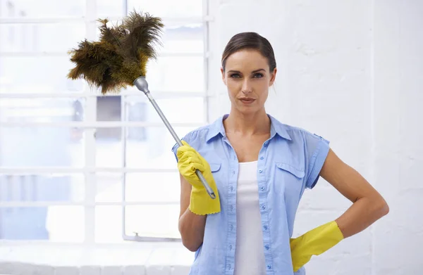 That dust dont stand a chance. a woman holding a feather duster in rubber gloves