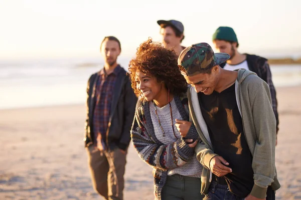 彼らは皆を止め 見詰める 日没時にビーチを歩いている友人のグループが — ストック写真