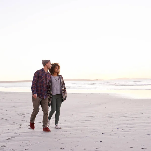 看落日 一对年轻夫妇在海滩上散步 — 图库照片