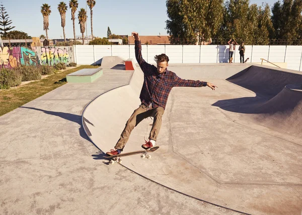 生活在边缘 一个年轻人在溜冰场的滑板上耍花样 — 图库照片