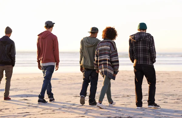 人生は友人との方が良い 日没時にビーチを歩いている友人のグループが — ストック写真