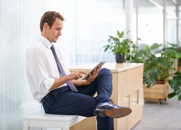 stock image Planning his vacation. a businessman using a digital tablet in an office environment