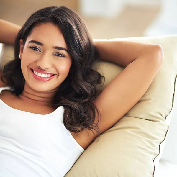 stock image Relax, smile and portrait of woman on sofa for happy, luxury and lifestyle. Comfortable, happy and content with girl lying on couch in living room at home for lounge, break and rest on weekend.