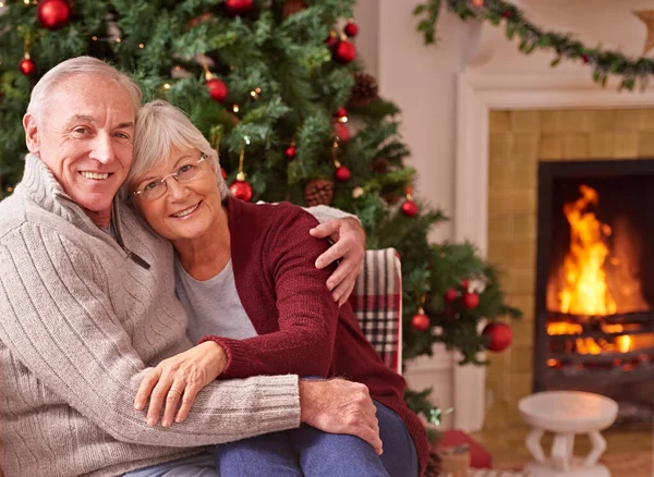 在圣诞节派对上 或者在他们家的客厅里庆祝放松的时候 肖像和老两口在一起 老年男女拥抱在一所房子里的圣诞盛会上 — 图库照片