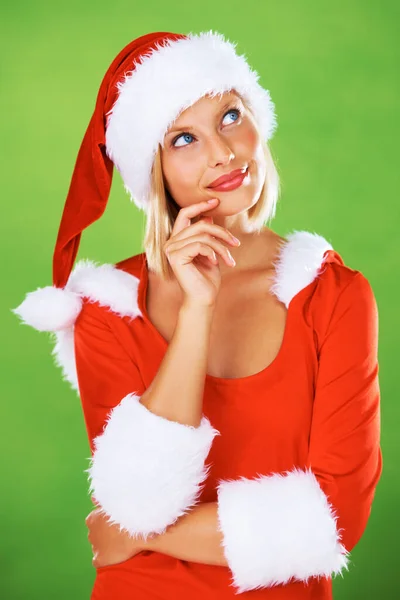 クリスマス 女性やアイデア 質問やお祝い 休日や冬のイベントの夢についてのスタジオ緑の背景に考えています お祝いの赤い衣装 サンタの帽子のモデルと意思決定について疑問 — ストック写真