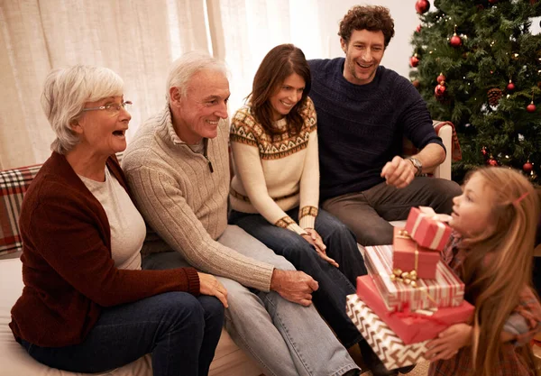 クリスマス 幸せな家族 冬の休日のお祝いに自宅で興奮祖父母への贈り物を持つ子供 うわー 母親と父親とともに若い女の子子供与えますプレゼントボックスに老人と女性 — ストック写真