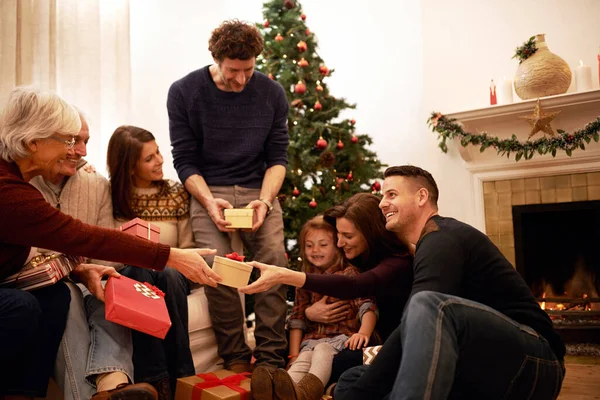 Family, christmas and holiday gift event of mother, dad and children with grandparents happy. Party and celebration event of people giving present box with thank you and gratitude on holiday at home.