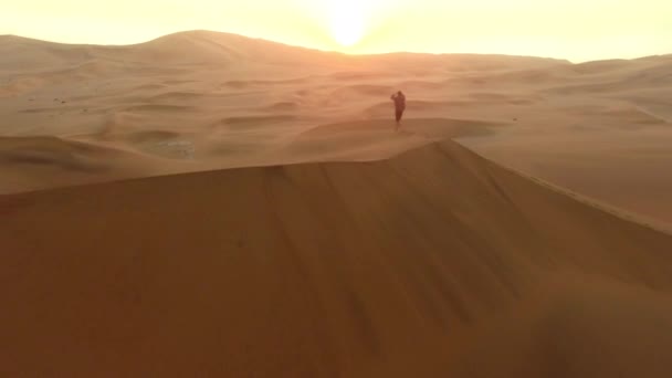 ドローン 人が歩く 砂の丘や風景砂丘 ナミビアの乾燥した土地での自由と休日の旅行 男性の散歩 水平線と休暇や冒険 自然の中での旅行や空中の景色 — ストック動画