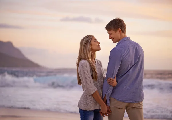 爱情只是一个词 直到你赋予它意义 一对快乐的年轻夫妇在夕阳西下的海滩上享受着浪漫的时光 — 图库照片