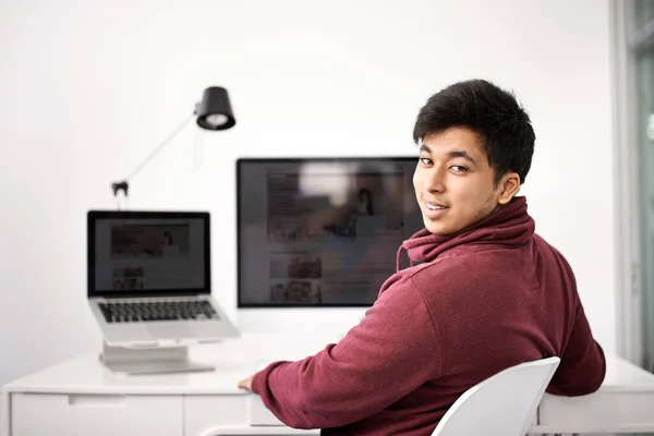 His IT expertise will live up to your expectations. Portrait of a young man sitting at his computer desk