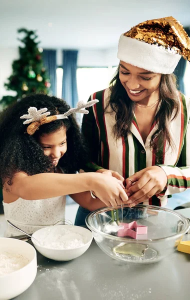 Black woman, girl and christmas baking in kitchen for learning, teaching and domestic skills in family home. Cooking, mother and daughter in house for holiday cookies, festive food and celebration.