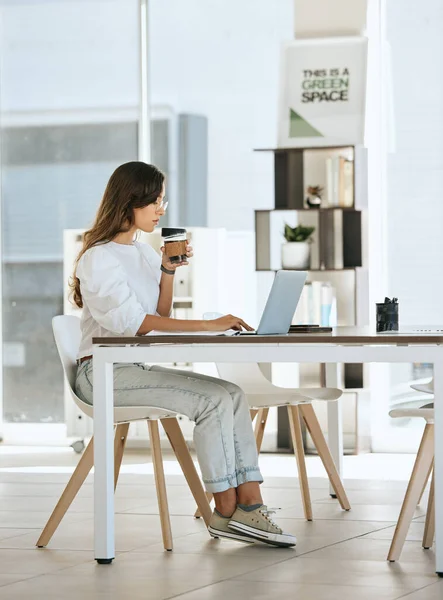 Laptop, coffee and business woman in office drinking espresso or cappuccino. Computer, tea and female from Canada with hot beverage while typing report, research or reading email in company workplace.