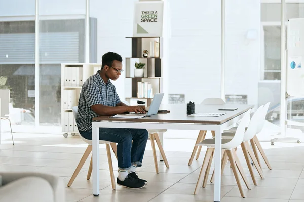 Creative, designer and laptop in web design or online marketing, advertising or development at the office. Black man employee working on computer in design for corporate company at the workplace.