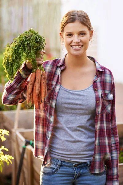 幸福属于自给自足的人 一个拿着一堆刚摘好的胡萝卜的快乐的年轻女人 — 图库照片