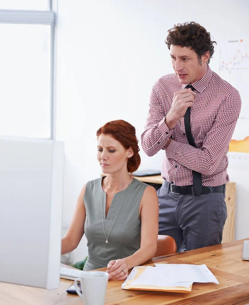 Tackling a problem together. two business professionals working together in front of a computer