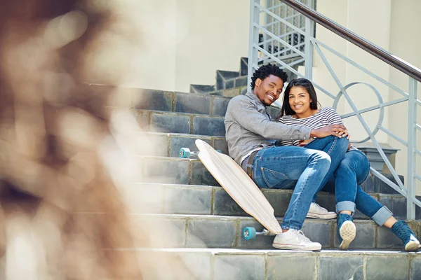 stock image Couple, happy and skateboard while sitting on stairs with hug, love and romance in city sunshine. Black couple, urban happiness and outdoor with skater, embrace and romance on steps in San Francisco.