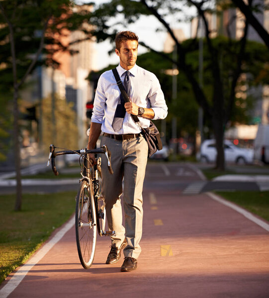 Enjoying the urban lifestyle. a businessman commuting to work with his bicycle
