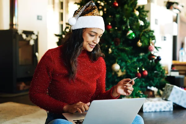 Woman, laptop and credit card in ecommerce for Christmas gift, online shopping or banking at home. Happy female using computer and bank card for digital transaction, purchase or payment for presents.