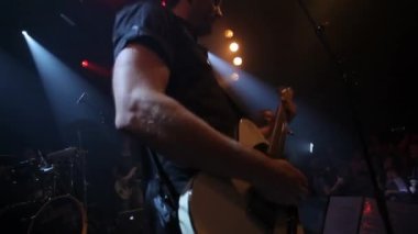 Rock, gitar ve konser portresindeki adam Los Angeles, ABD 'de göz kırpan ve enerjik bir performans sergiliyor. Canlı müzik, orkestra ve mutlu elektro gitarist kalabalıkla sahnede coşkuyla çalıyor.