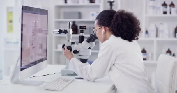 在实验室与黑人妇女一起进行医学 疫苗和生物技术方面的研究 科学和音乐 配备显微镜和计算机 科学家聆听耳机的分析 创新和想法 — 图库视频影像