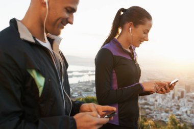 Harika melodilerle yola çıkmaya hazır olun. Çalışmalarından önce cep telefonlarından müzik seçen bir çift.