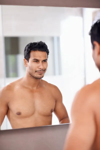 stock image Damn, I look good. A handsome young man admiring himself in the mirror