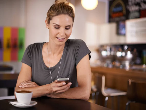今日のニュースアプリのトップ記事をチェックしてください 喫茶店に座っている間に魅力的な女性のテキストメッセージ — ストック写真