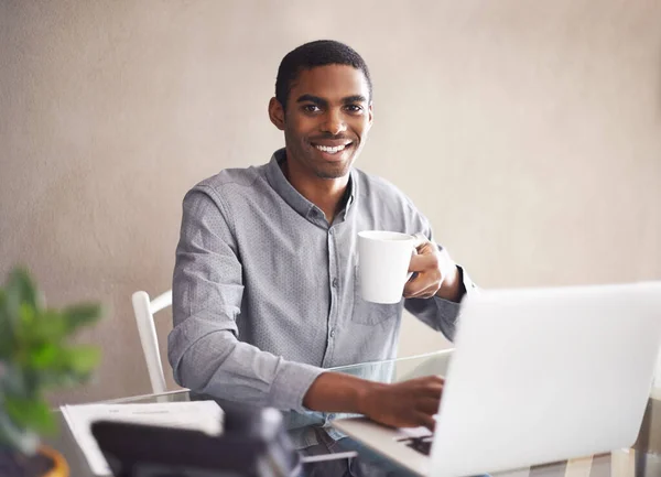 その日の準備ができている人 自宅のノートパソコンで仕事をしながらハンサムな若い男がコーヒーを飲む姿 — ストック写真