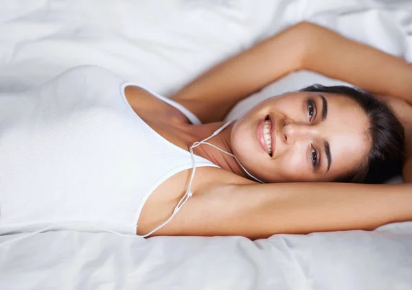 休みの日に私は時間 ベッドの上に横たわりながら音楽を聴く美しい若い女性の肖像画 — ストック写真