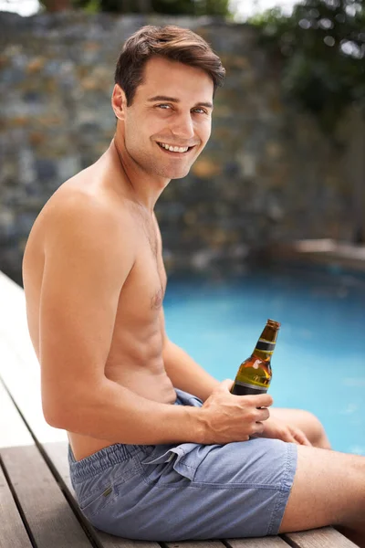 太陽とプールと飲み物を手に入れました プールサイドにビールを持っている男の肖像画 — ストック写真