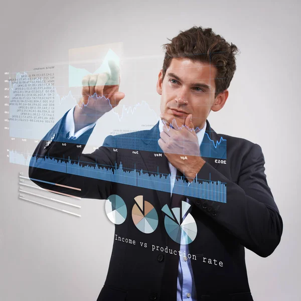 These finances are looking good. a thoughtful-looking businessman using a digital interface