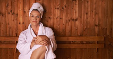 Enjoying the simple things in life. a mature woman in a sauna clipart