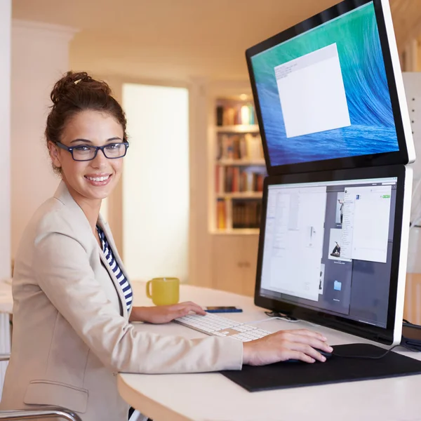 Have you made the upgrade to dual-screen. Portrait of a young woman working on a dual-screen computer at home
