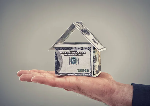 He can buy his dream home now. Close up conceptual shot of a man holding money that has been made to look like a house