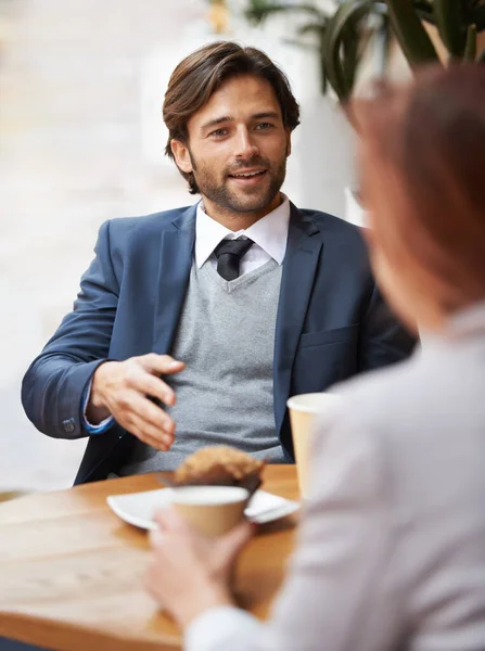 Coffee shop business discussions. A businessman and woman having a meeting over coffee